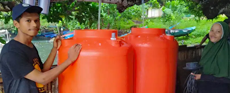 Rifaldi und Farista mit den 1000-Liter-Tanks zur Aufzucht der Korallenlarven (Planula-Larven).